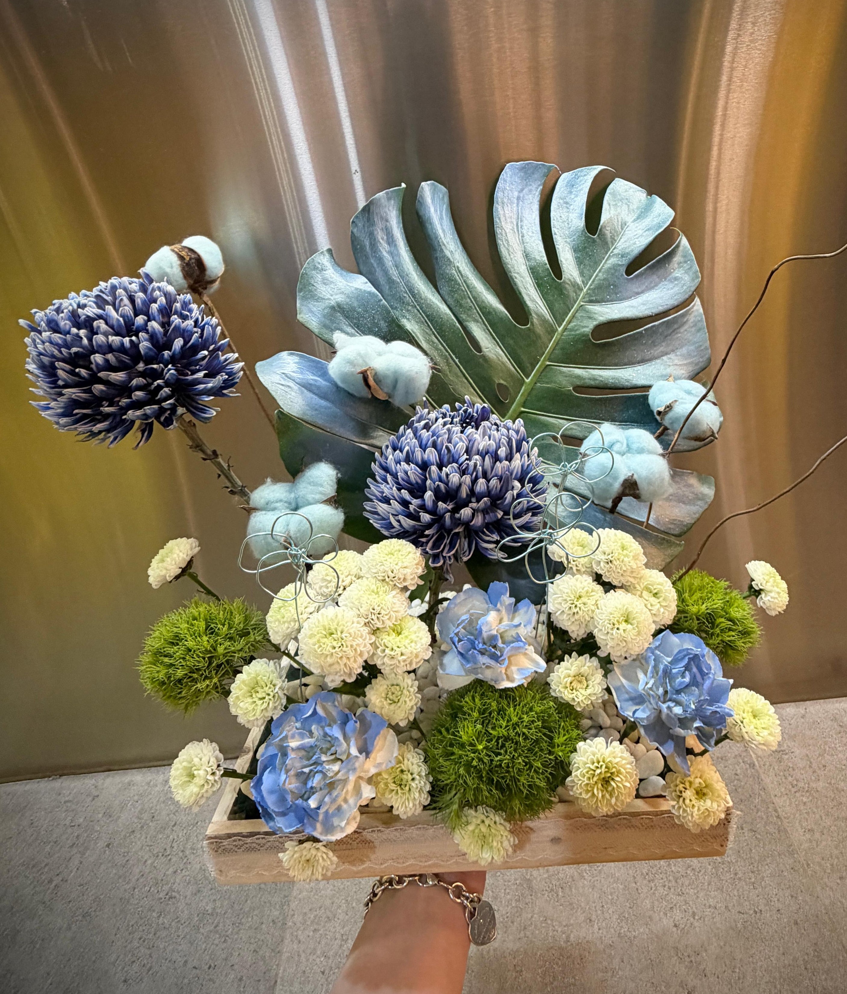 Blue Theory baby boy tray arrangement with blue flowers and cotton