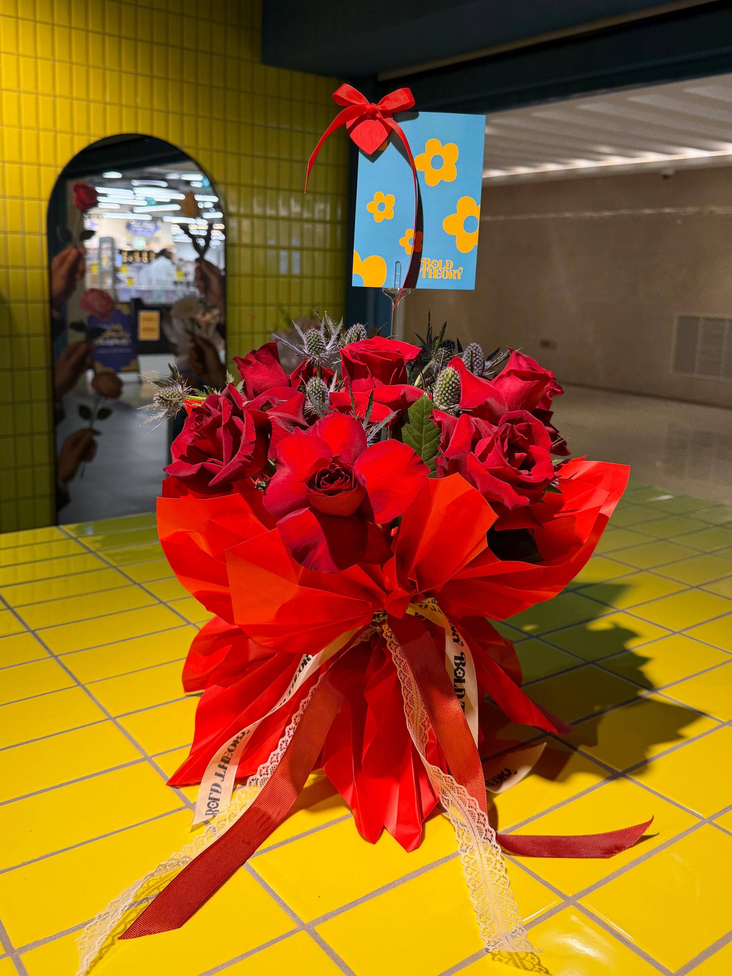Lady in Red red rose bouquet with statement bow and ribbon accents