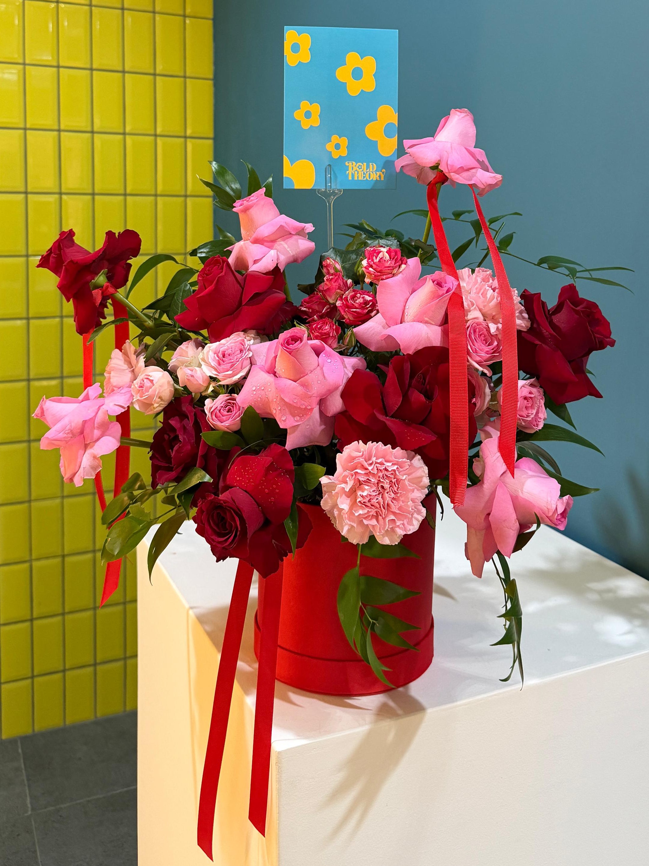 Loving Heart romantic arrangement with red and pink roses, spray roses, carnations and ribbon accents